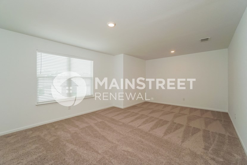 a living room with a carpeted floor and a window