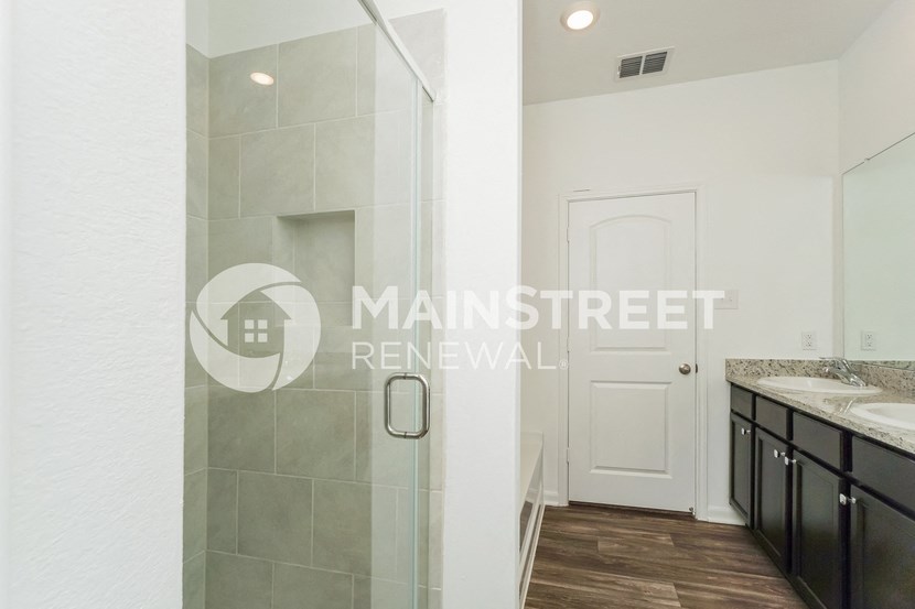a bathroom with a shower and a sink and a mirror