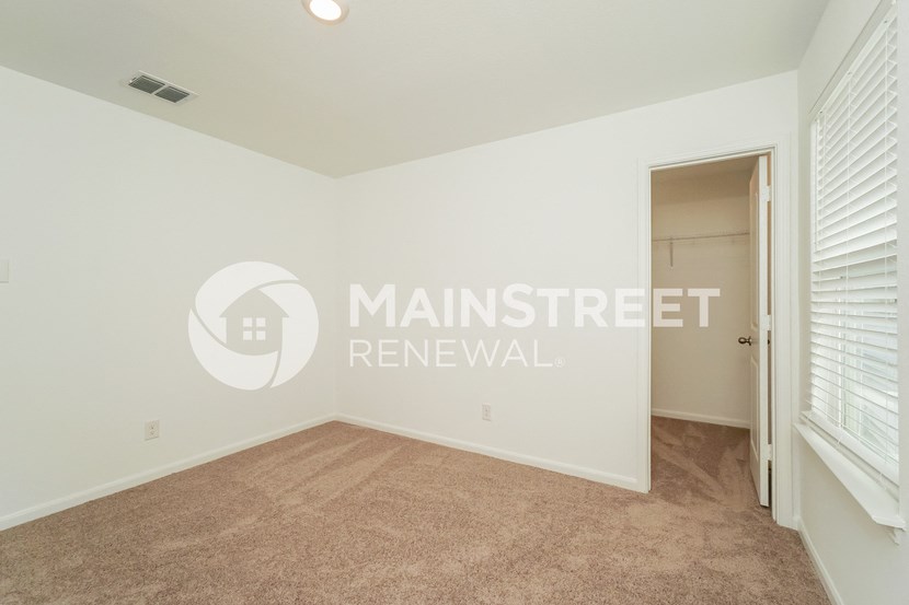a bedroom with a carpeted floor and a door to a closet