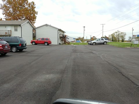 A parking lot with cars and a red car in the middle.