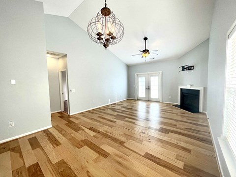 the living room has a hardwood floor and a chandelier