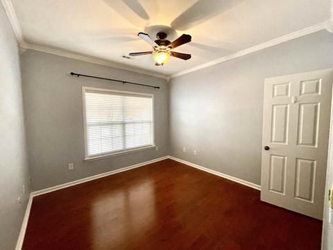 a empty room with a ceiling fan and a window and a door