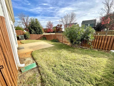 a backyard with a wooden fence and a yard with grass