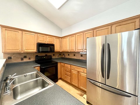 a kitchen with stainless steel appliances and wooden cabinets