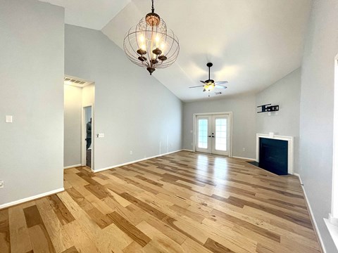 a large living room with a hardwood floor and a chandelier