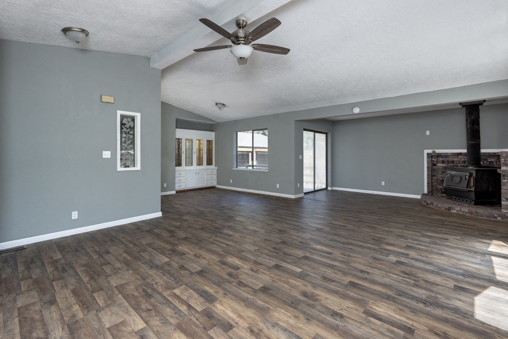 a living room with a fireplace and a ceiling fan