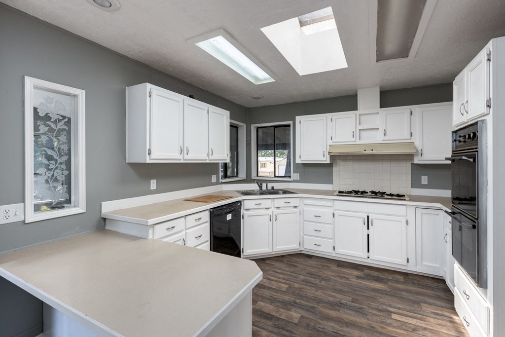 an open kitchen with white cabinets and stainless steel appliances