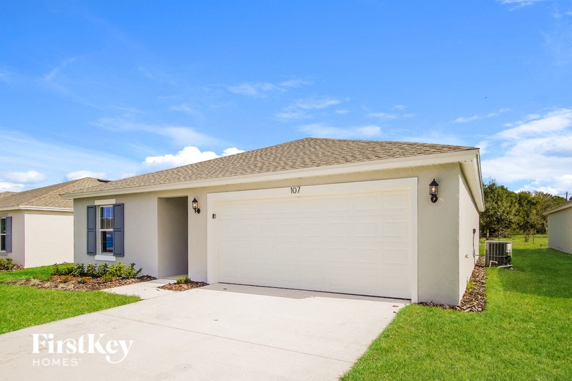 A house with a garage door and a sign that says "FirstKey Homes".
