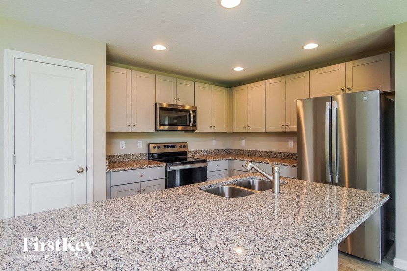 A kitchen with granite countertops and stainless steel appliances.