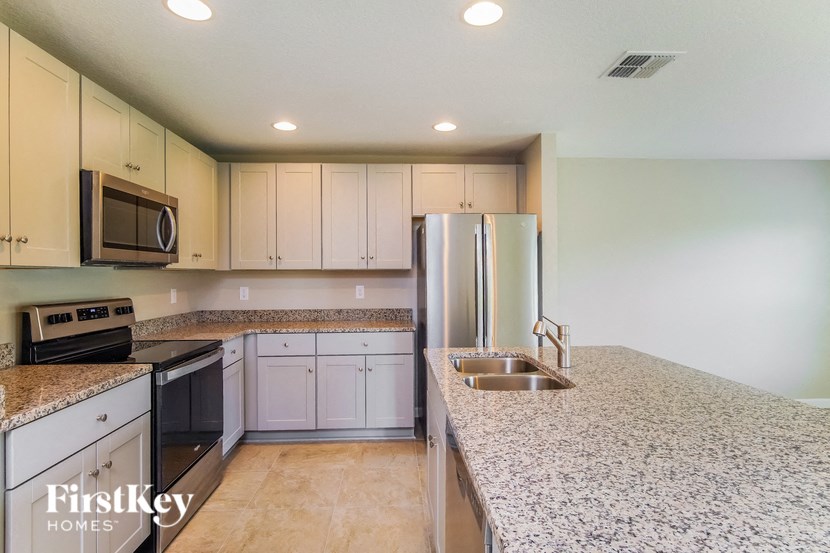 A kitchen with granite countertops and stainless steel appliances.
