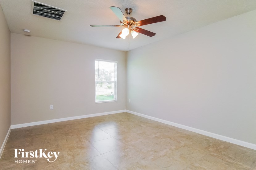 A room with a ceiling fan and a window.