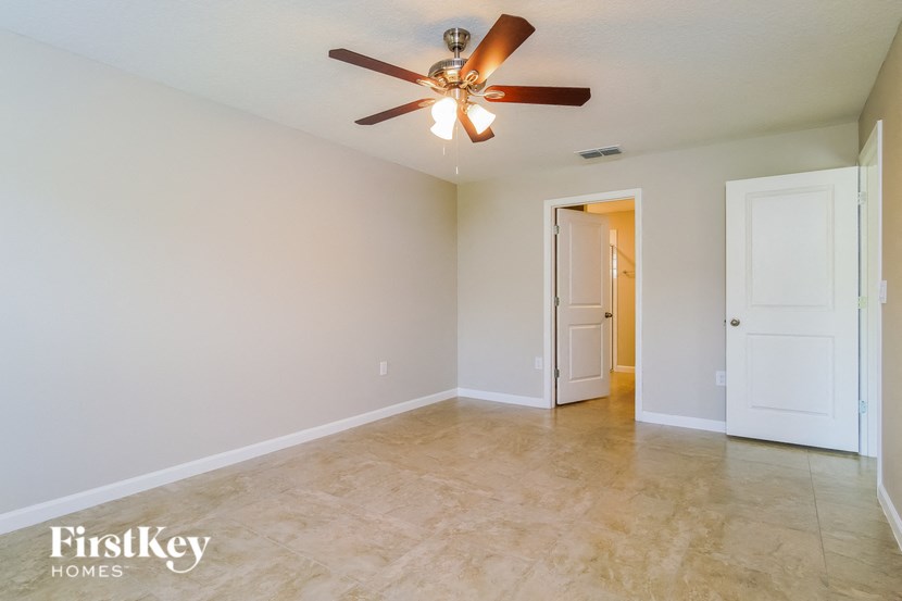A spacious room with a ceiling fan and tiled floor.