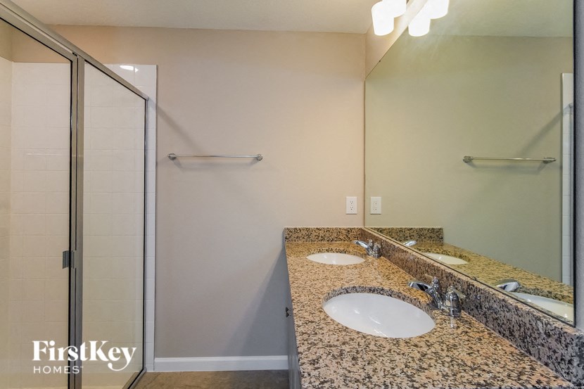 A bathroom with granite countertops and a large mirror.