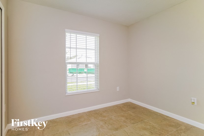A room with a window and a tiled floor.