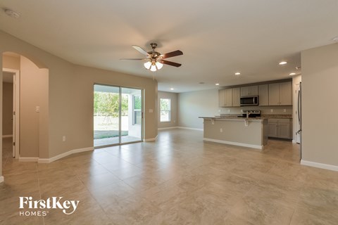 an empty kitchen and living room with a ceiling fan