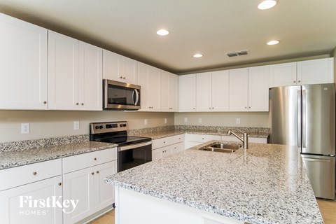 A kitchen with granite countertops and stainless steel appliances.