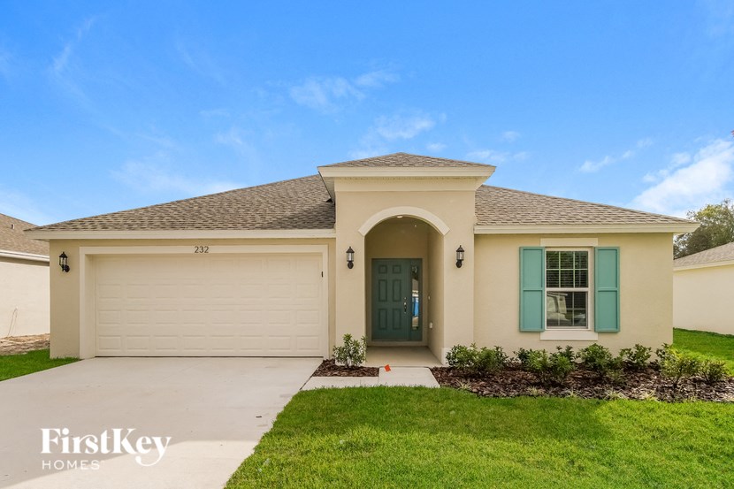 the exterior of a beige house with a green door