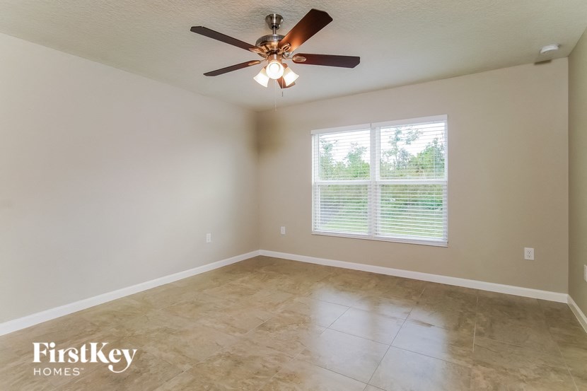 an empty room with a ceiling fan and a window
