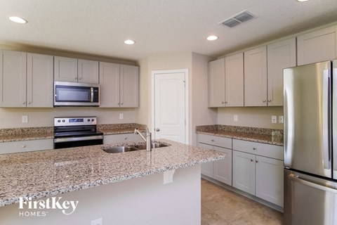 a kitchen with granite counter tops and white cabinets