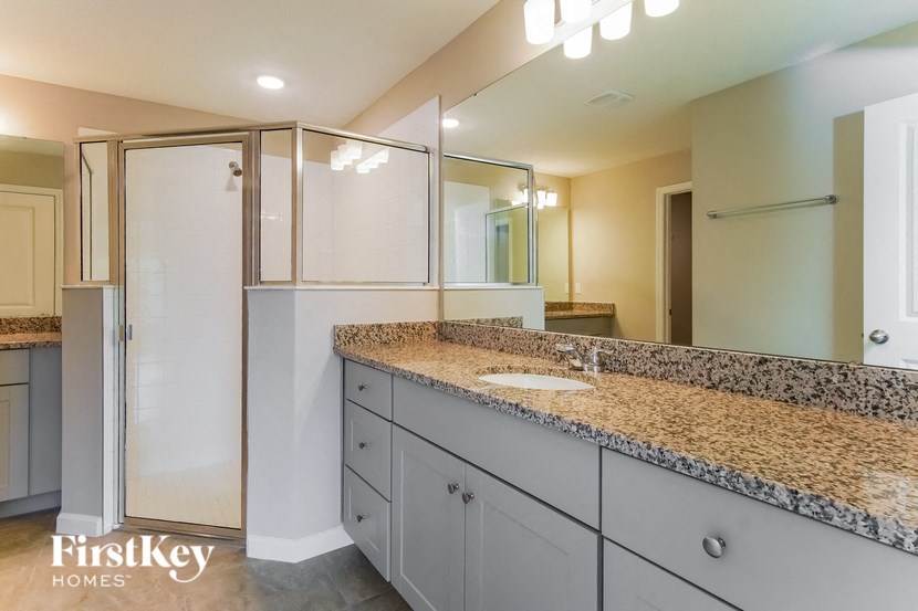 the master bathroom has a large shower and granite counter tops