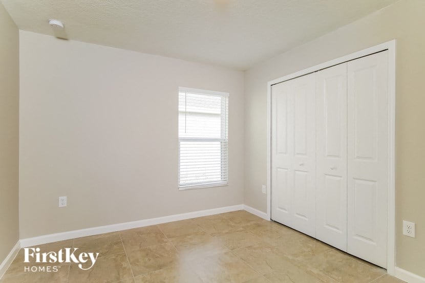 a living room with a large white door and a tile floor