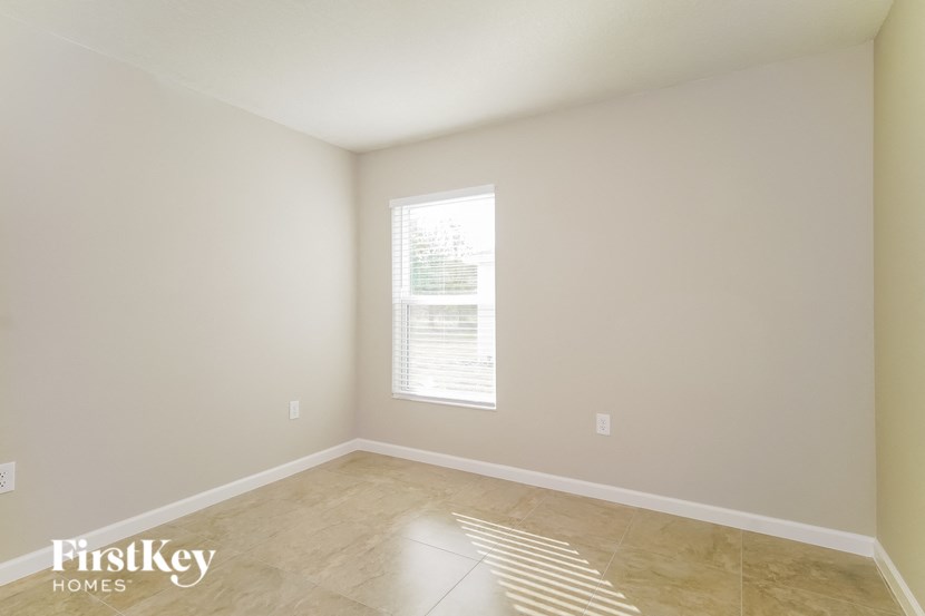 a empty room with a window and tile floors