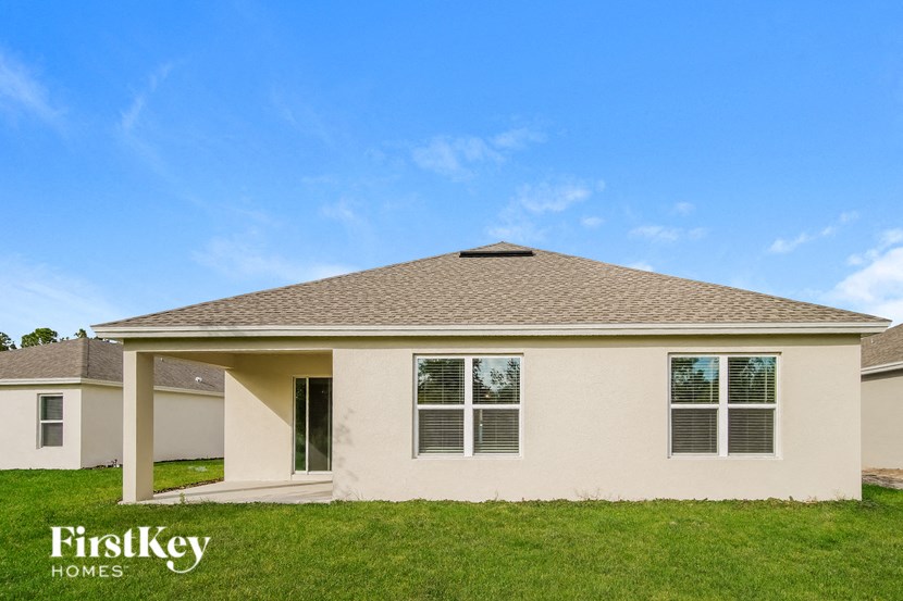 a beige house with a roof and grass