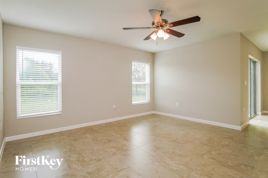 an empty living room with a ceiling fan