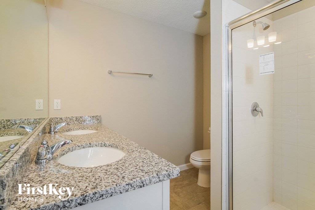 a bathroom with a sink and a shower and a toilet