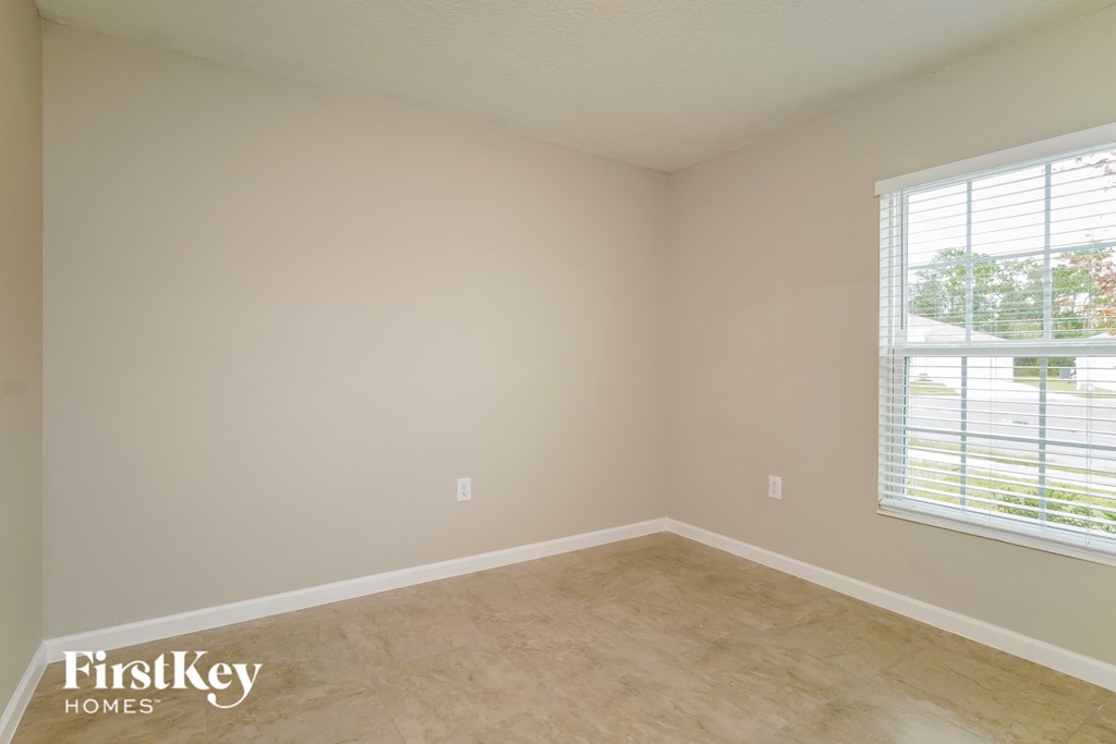 an empty room with a window and a wooden floor