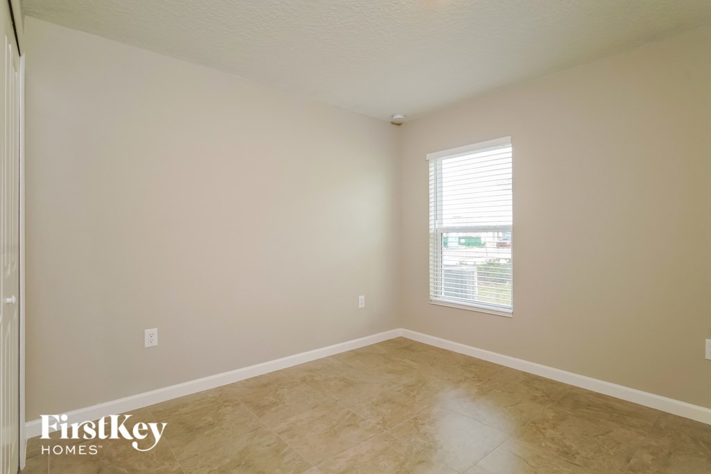 a empty room with a window and wooden floors