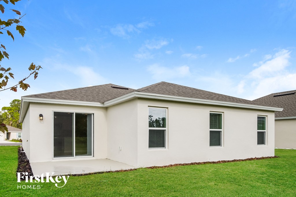 a white house with green grass and a blue sky
