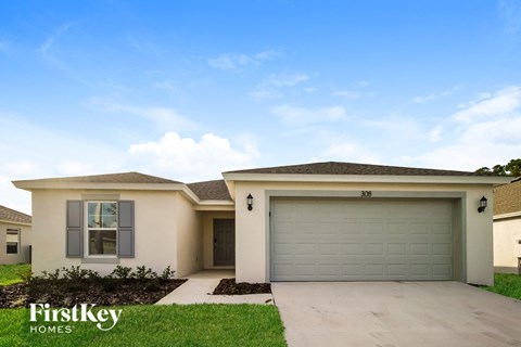 a beige house with a garage door and grass