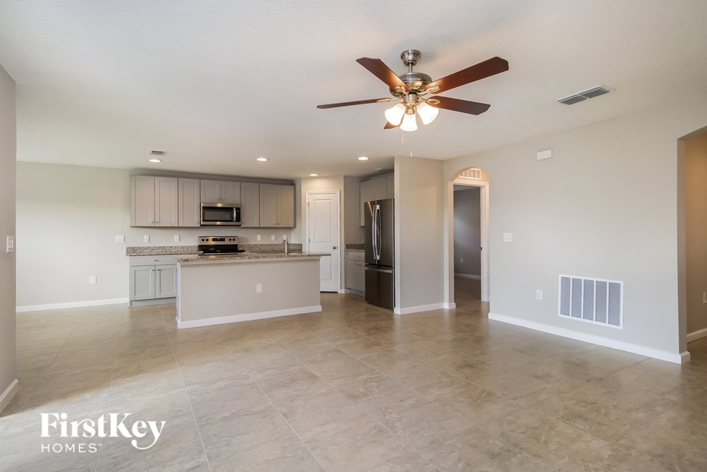 an open kitchen and living room with a ceiling fan