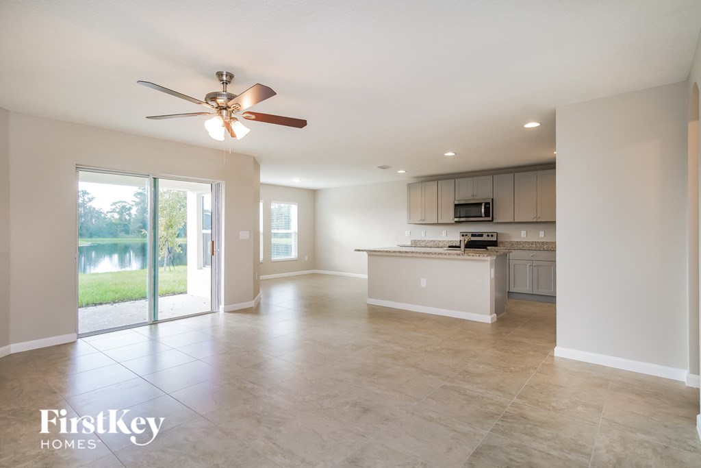 an open kitchen and living room with a sliding glass door to a lake