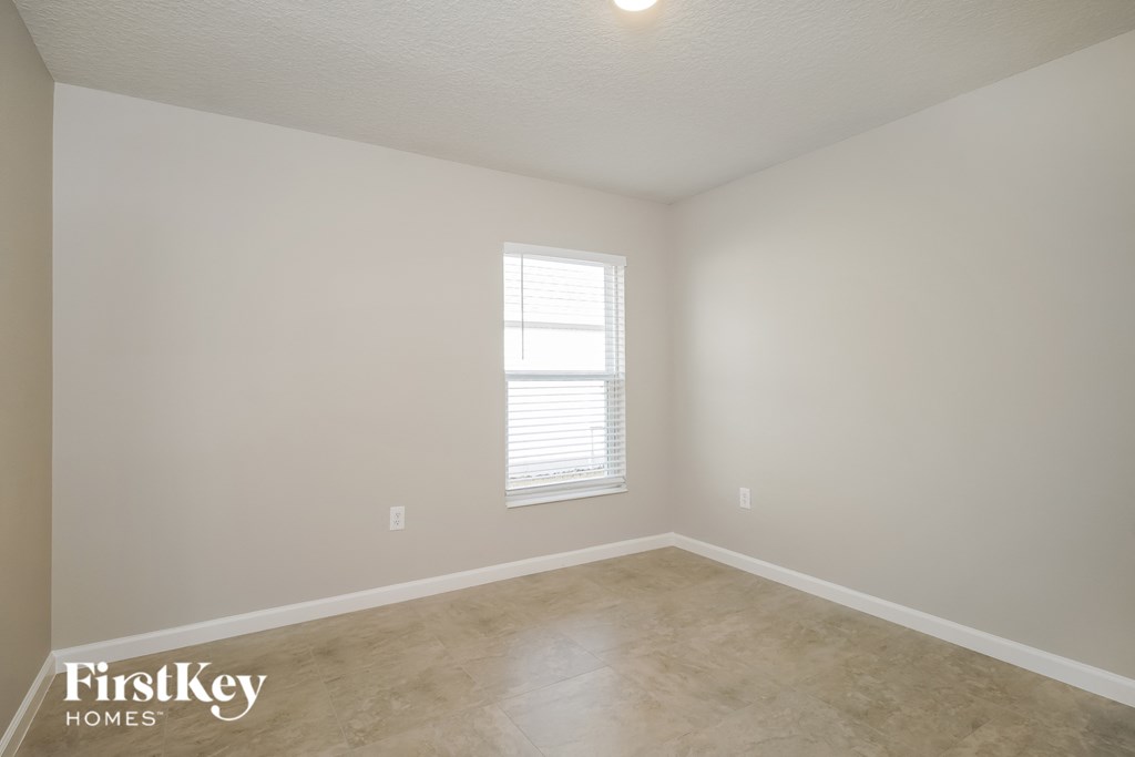 a living room with a window and a tiled floor