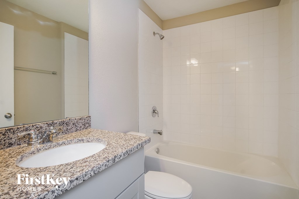 a bathroom with a tub and a sink and a toilet