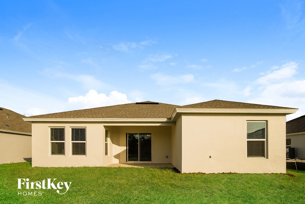 a beige house with a lawn and a blue sky