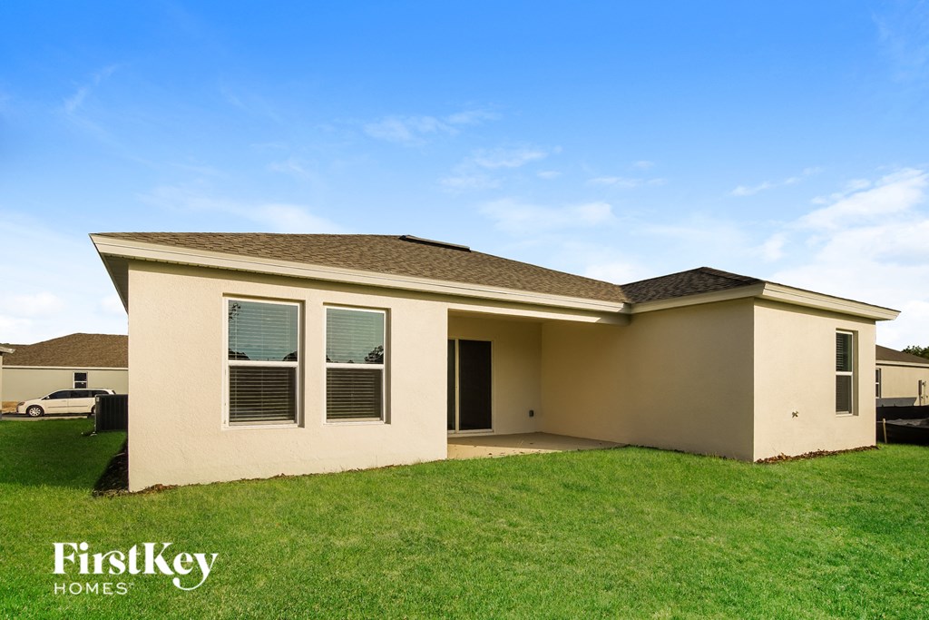 a beige house with a lawn and a blue sky
