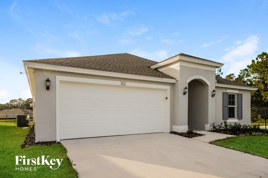 a beige house with a driveway and a garage door