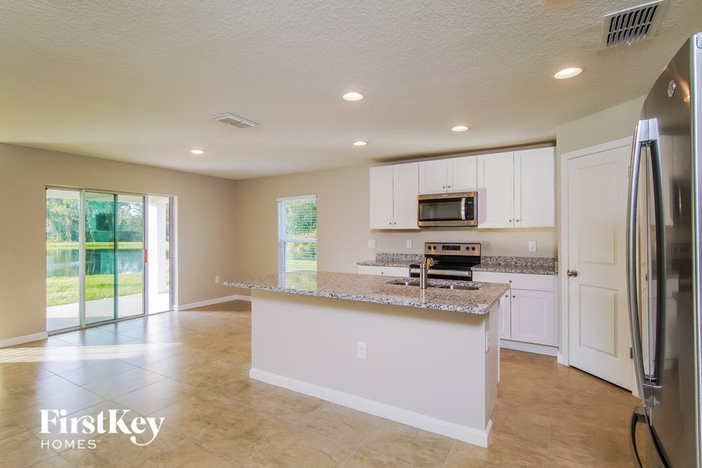 an open kitchen with a large island and stainless steel appliances