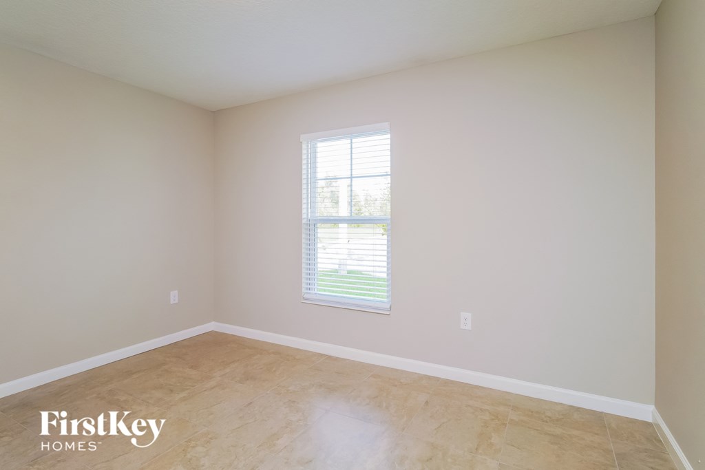 a room with white walls and a window and wooden floors