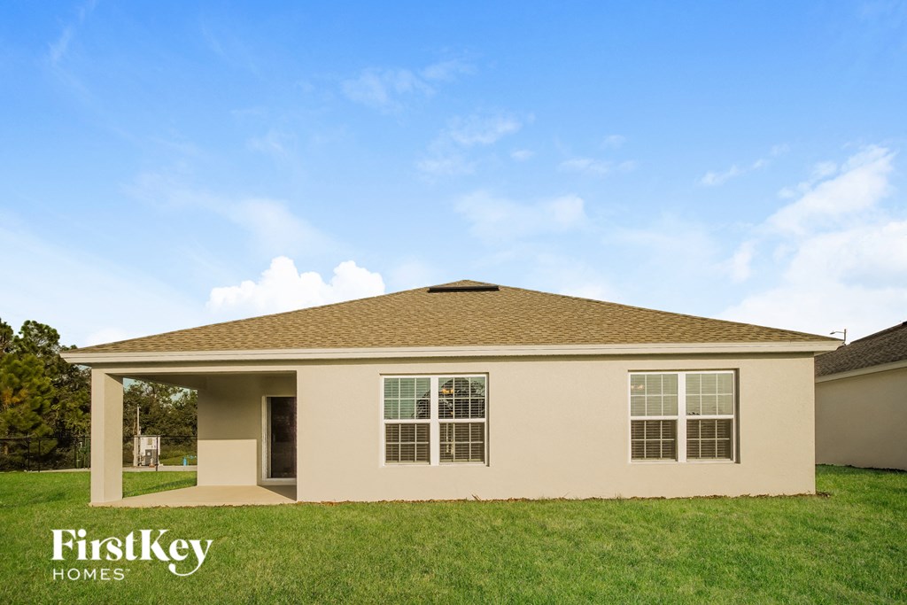 a beige house with brown roof on a green lawn
