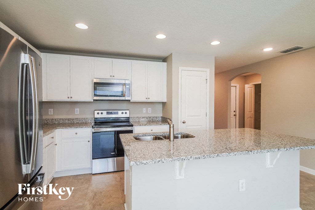 a kitchen with white cabinets and a granite counter top