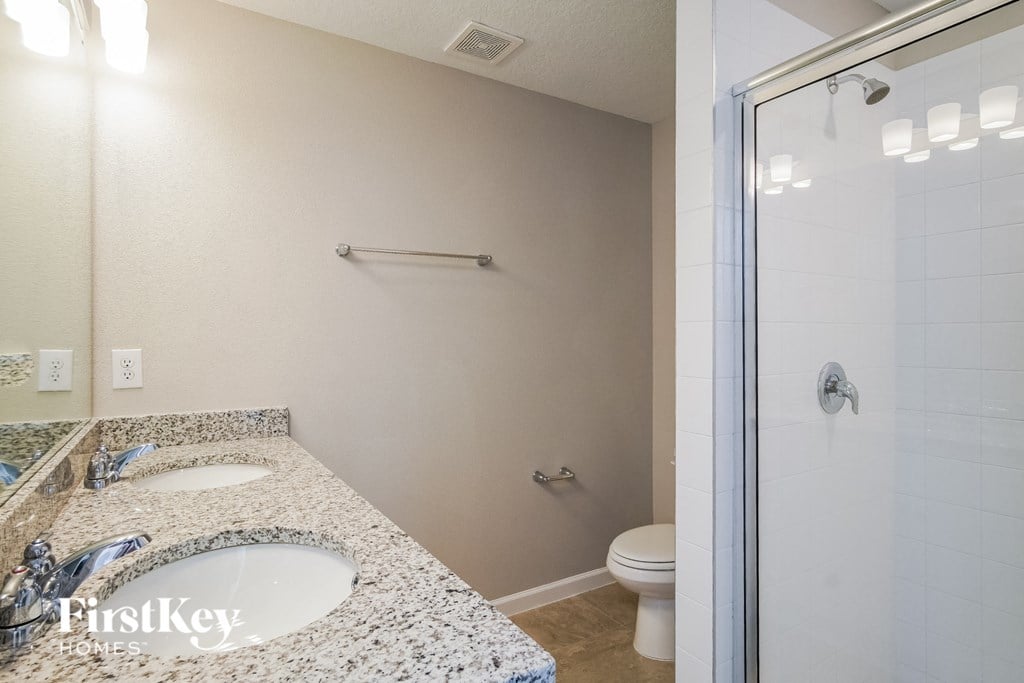 a bathroom with a sink and a shower and a toilet