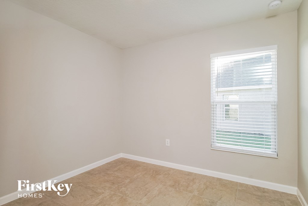 a empty room with a window and a tiled floor
