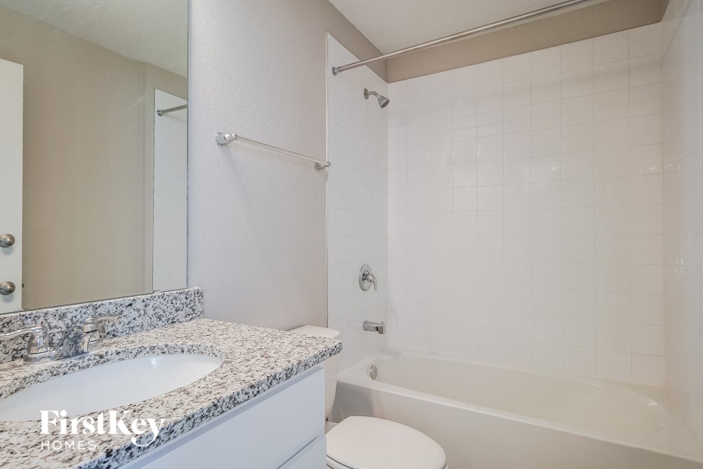 a bathroom with a tub and a sink and a toilet