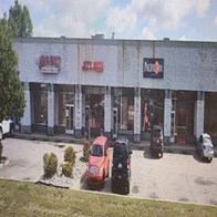 A red car is parked in front of a building with a sign that says "HopUp".