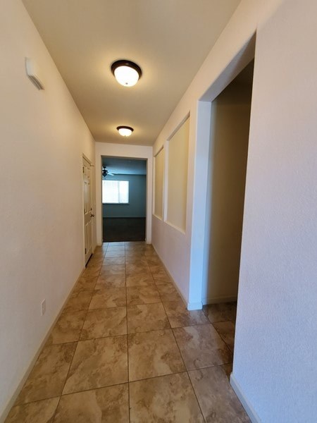 A long hallway with tiled floors and white walls.