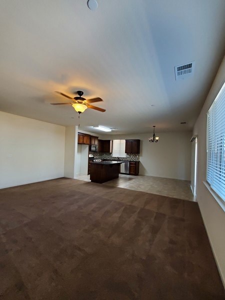 A room with a ceiling fan and carpeted floor.
